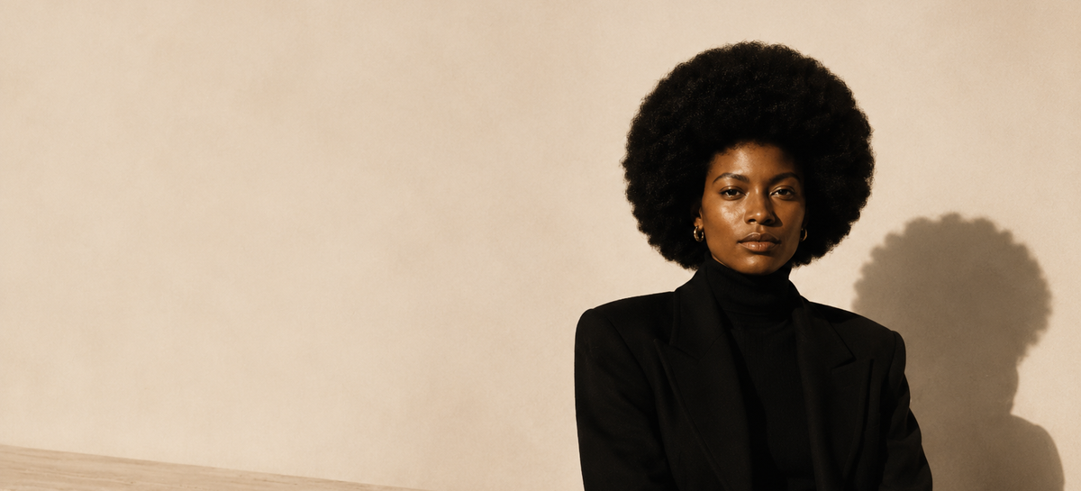 Afroyla editorial — model seated on travertine block